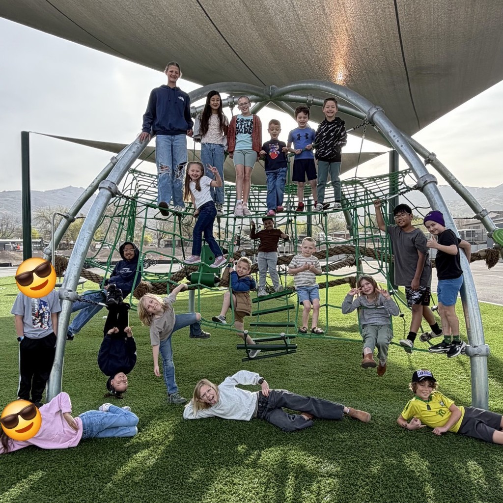 March Students of the Month at Bountiful Elementary pose together on a playground climbing structure outdoors while being recognized for setting a PAWSitive example at school.