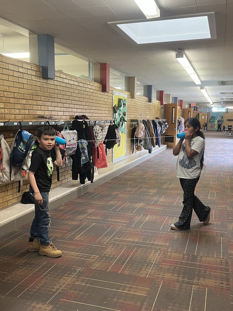 two students in the hall using a string telephone