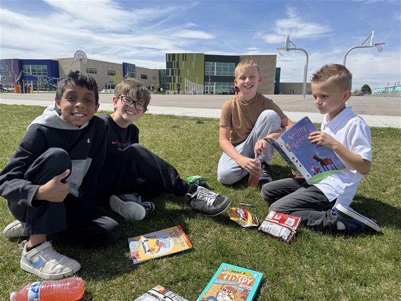four boys with books smiliing at camera