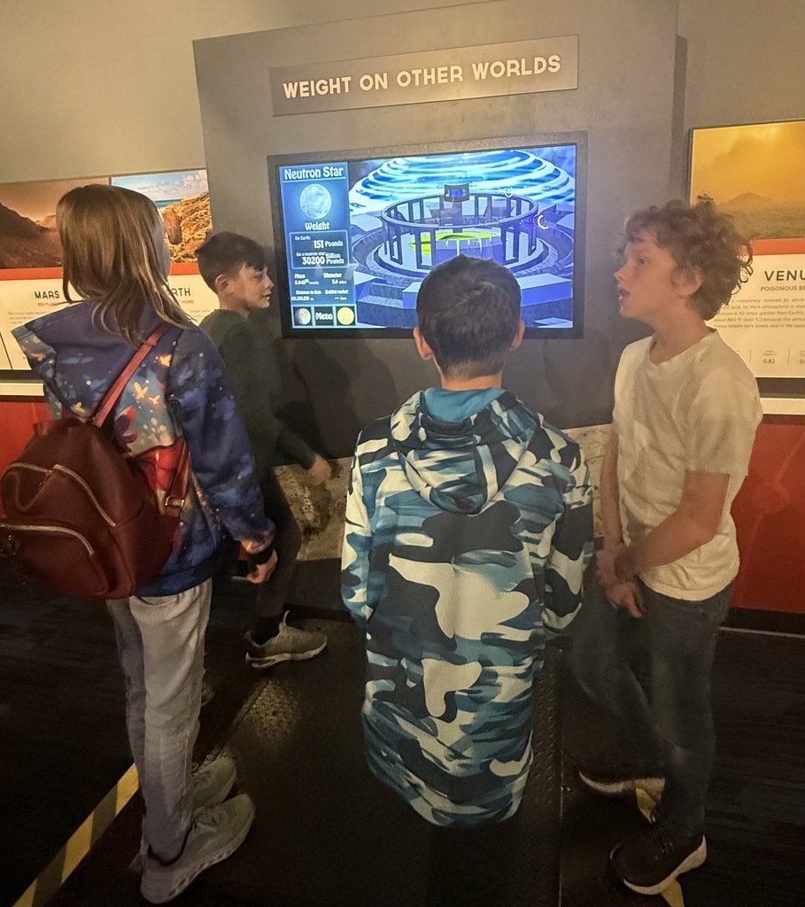 students standing on a scale to see what their weight would be on other worlds "planets"