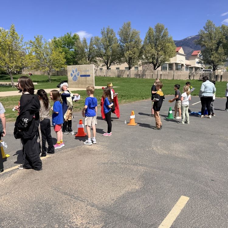 students showcasing their wax museum characters with others in the school