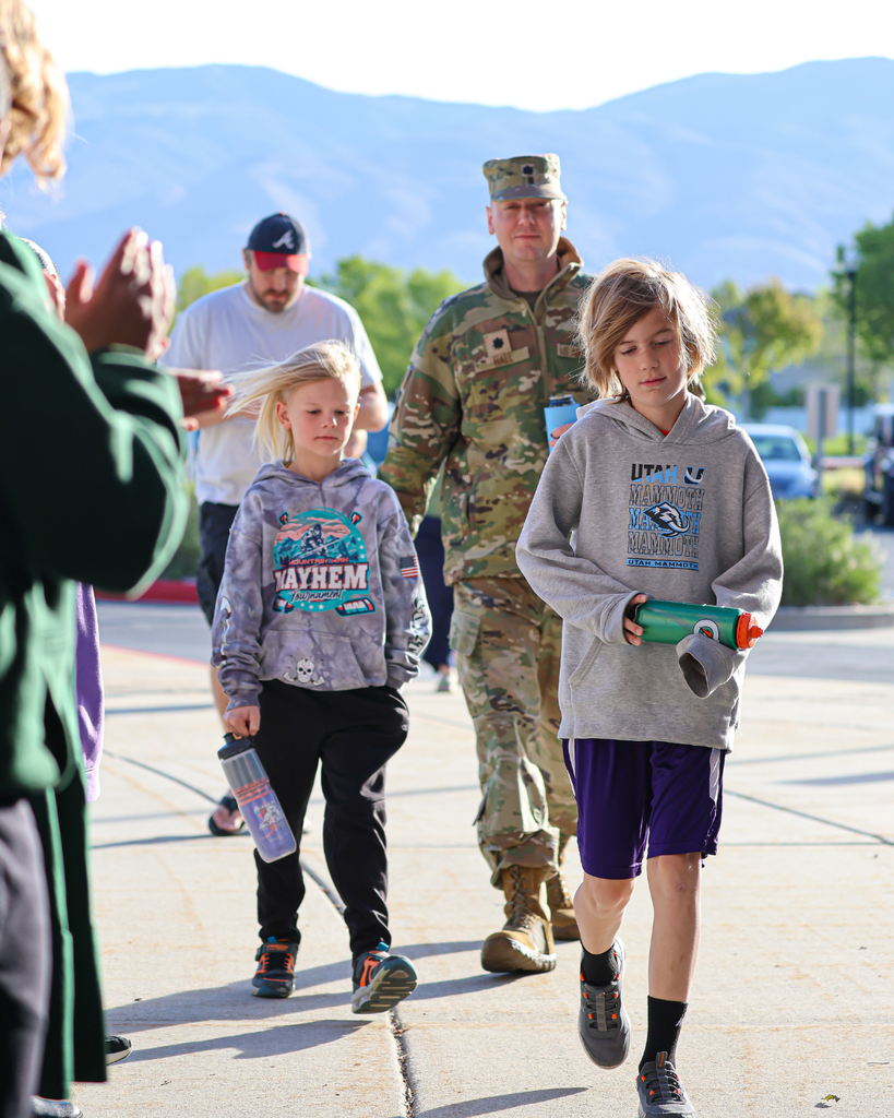 Two students and their parent dressed in military fatigues walk into a school.