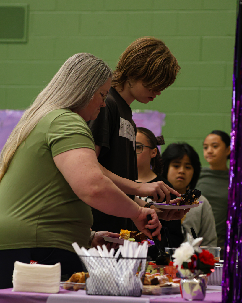 A line of people getting food at the Foxboro Military Appreciation Breakfast.