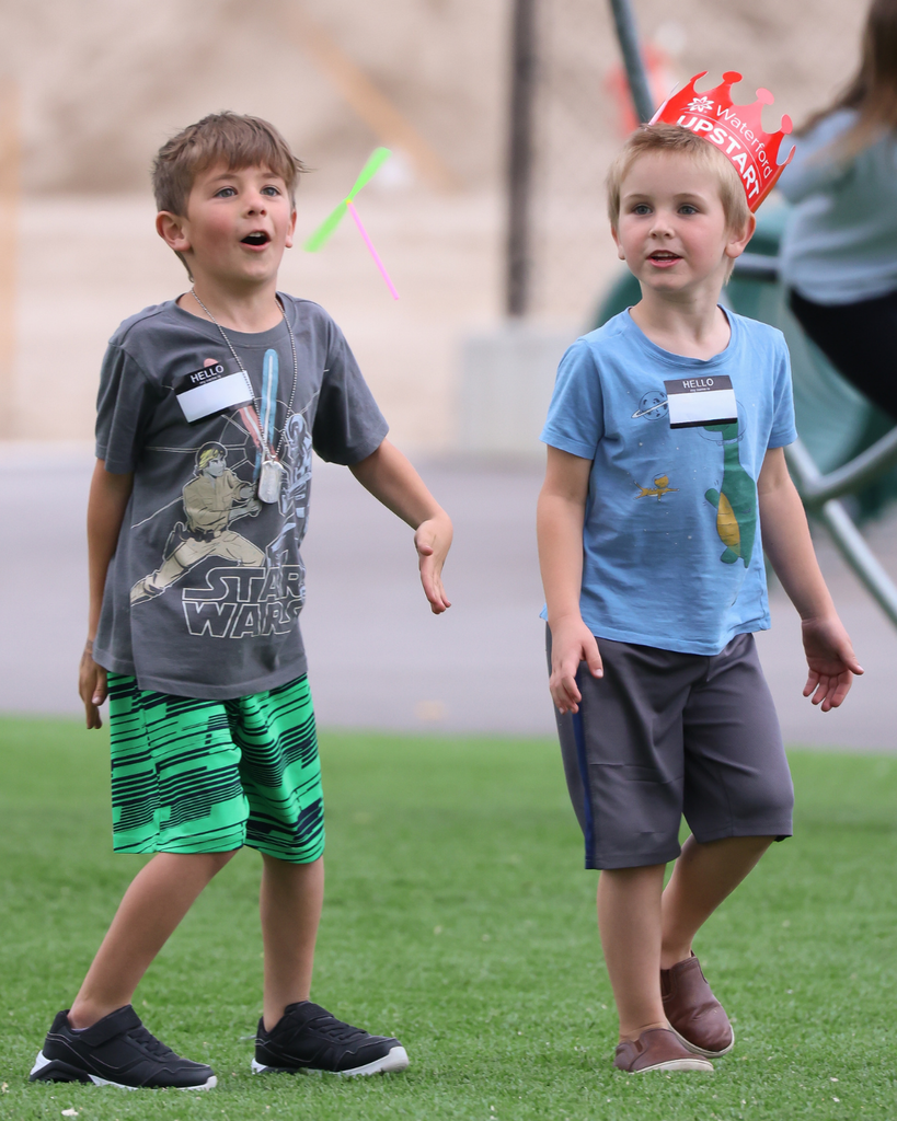 Two students throwing a spinner in the air and looking amazed.