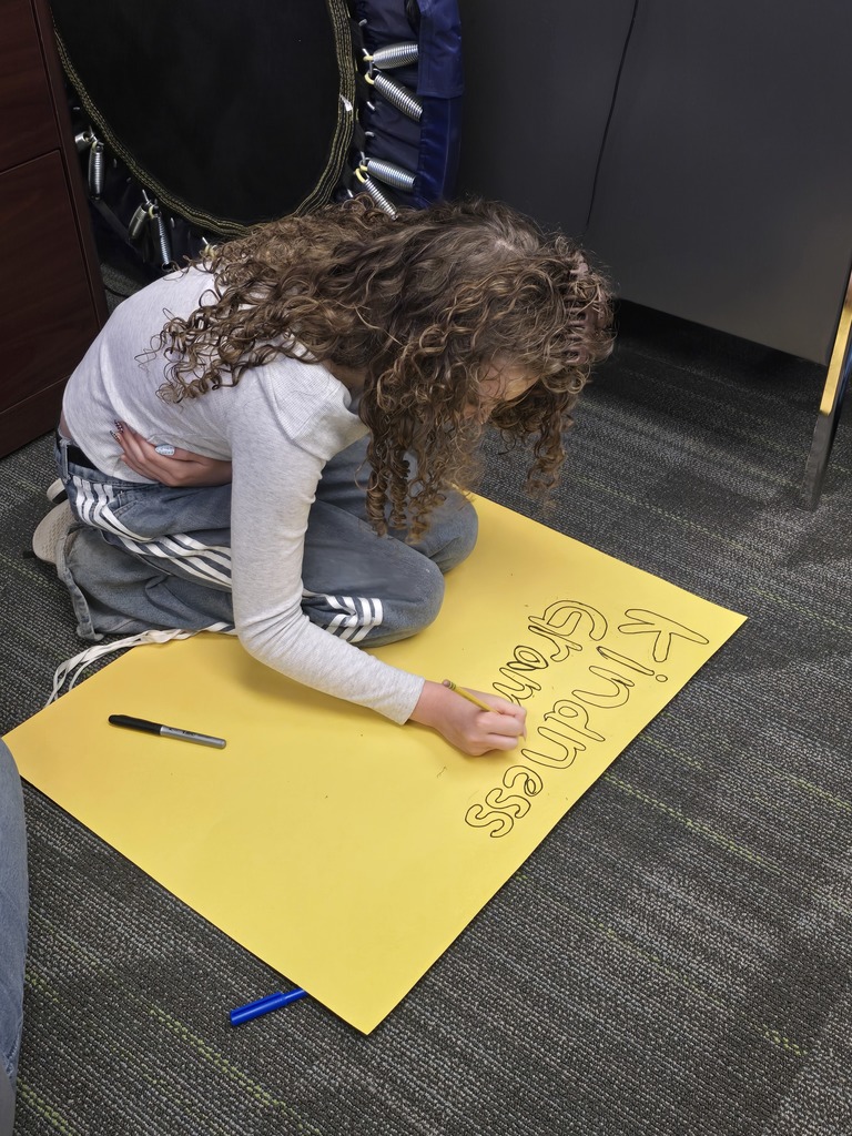 student drawing a poster for hope week