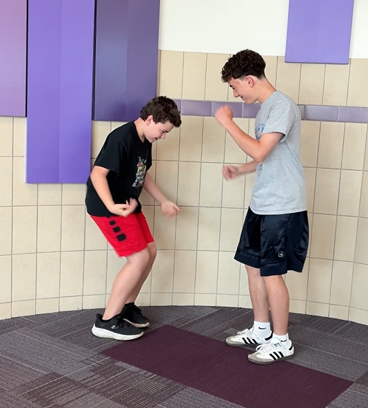 Students in the hallway having fun with a special handshake