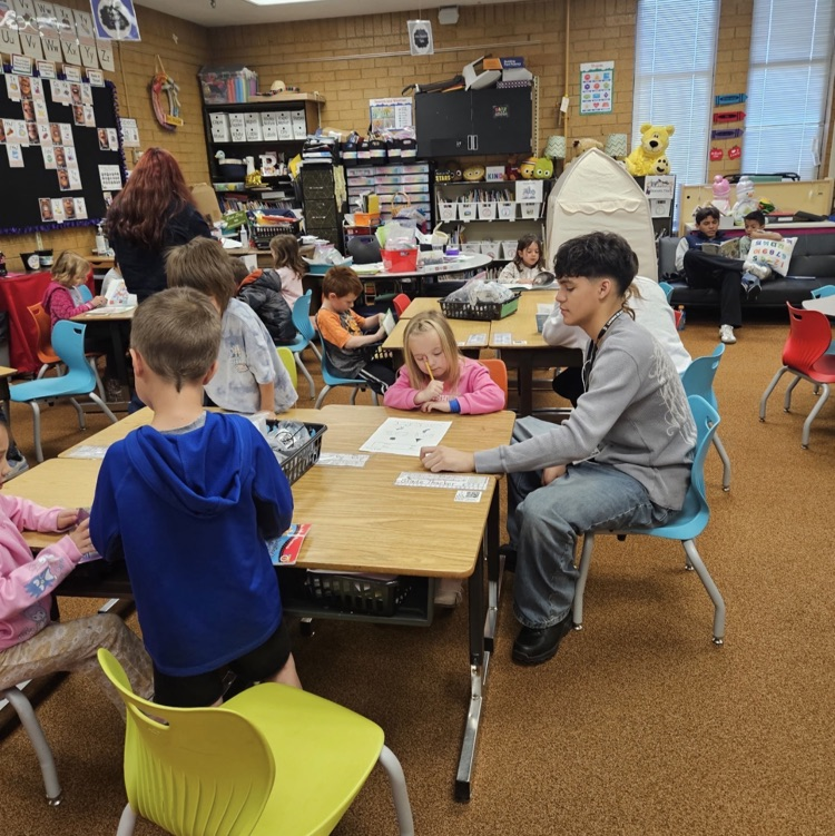 Latinos in Action from Layton High School working with kindergarteners on their reading. 