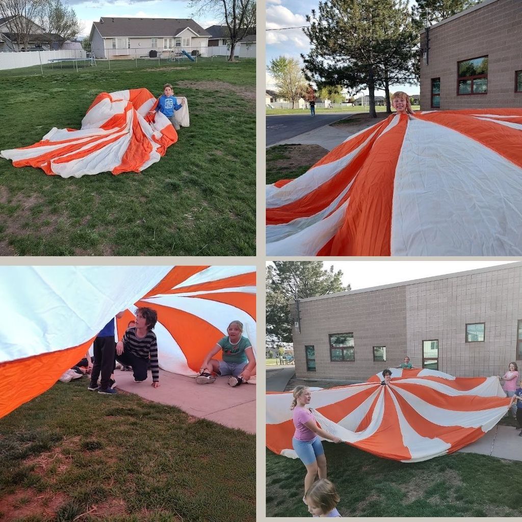 Students play outside a school with a big red and white parachute. 