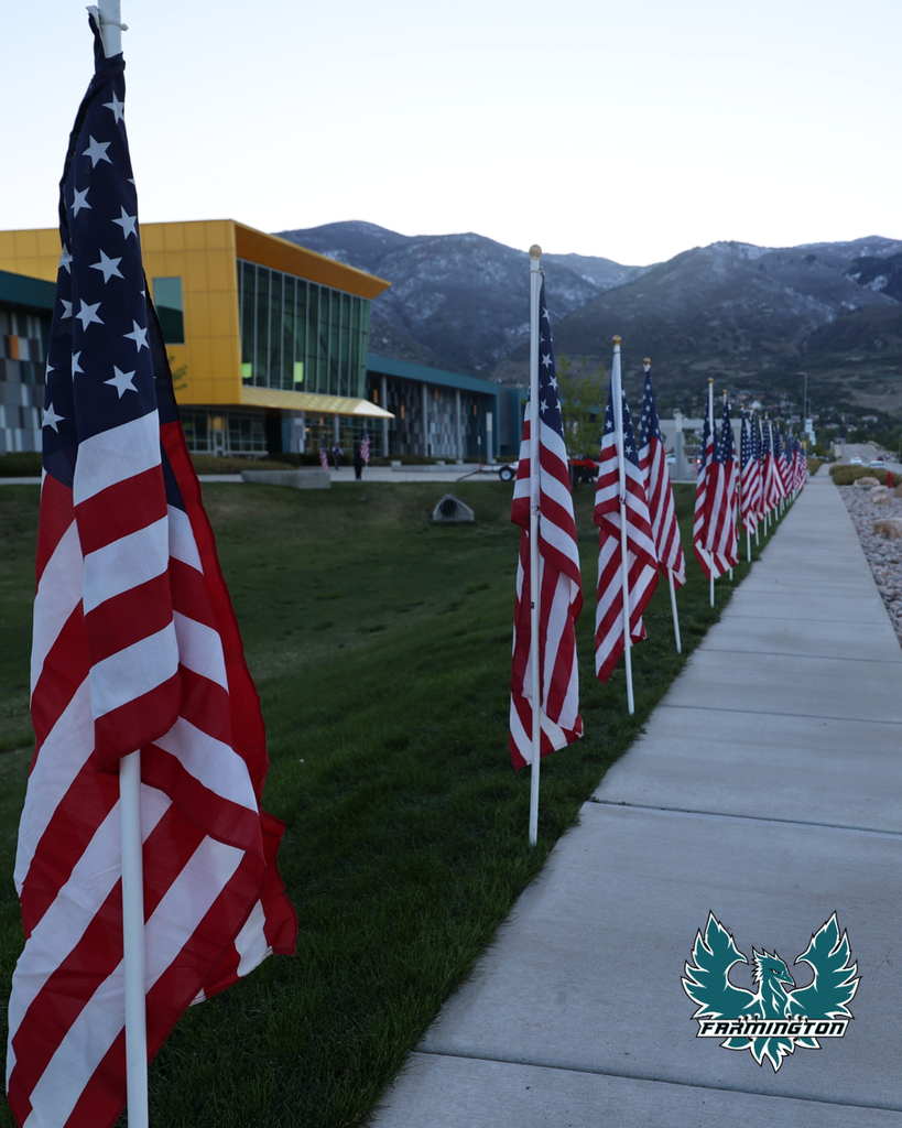 A row of full-size flags with the Farmington High  Logo in the bottom right.