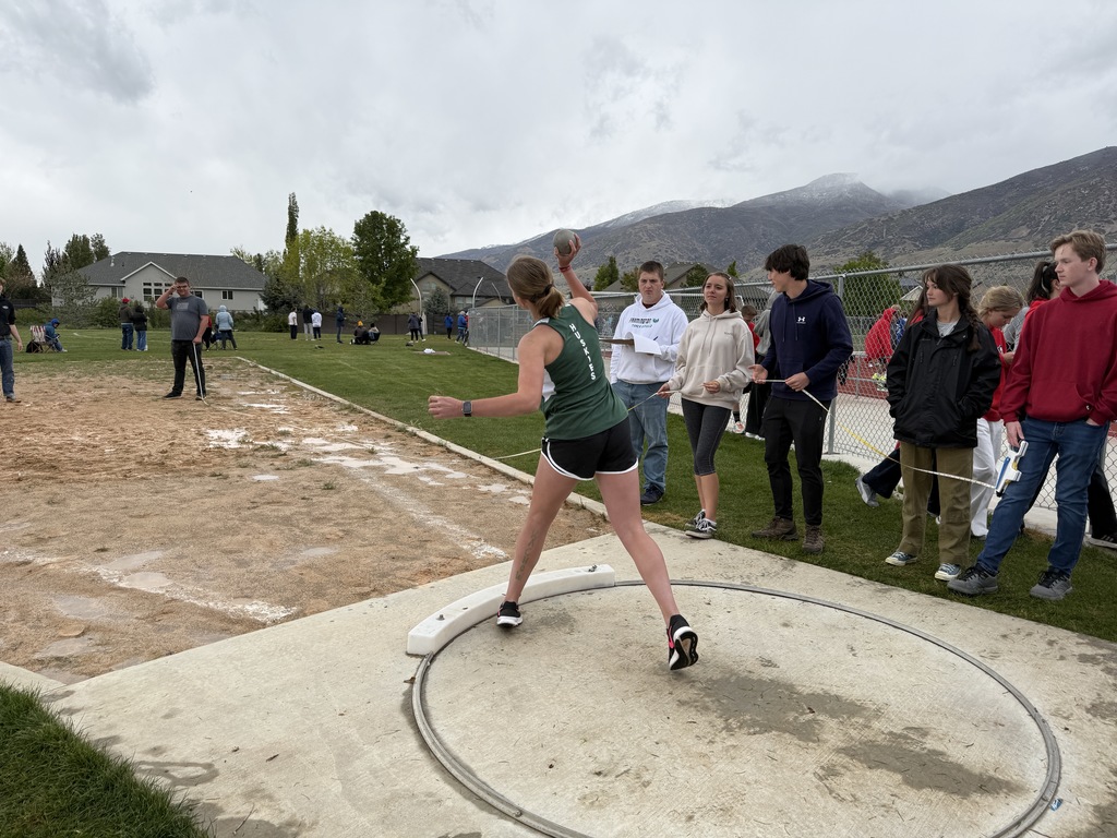 A student doing the shot put  event. 