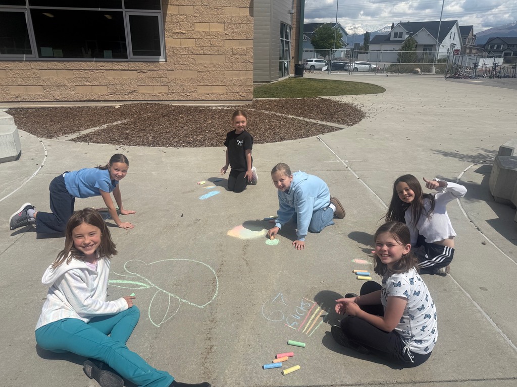 students pictured outside with their chalk art