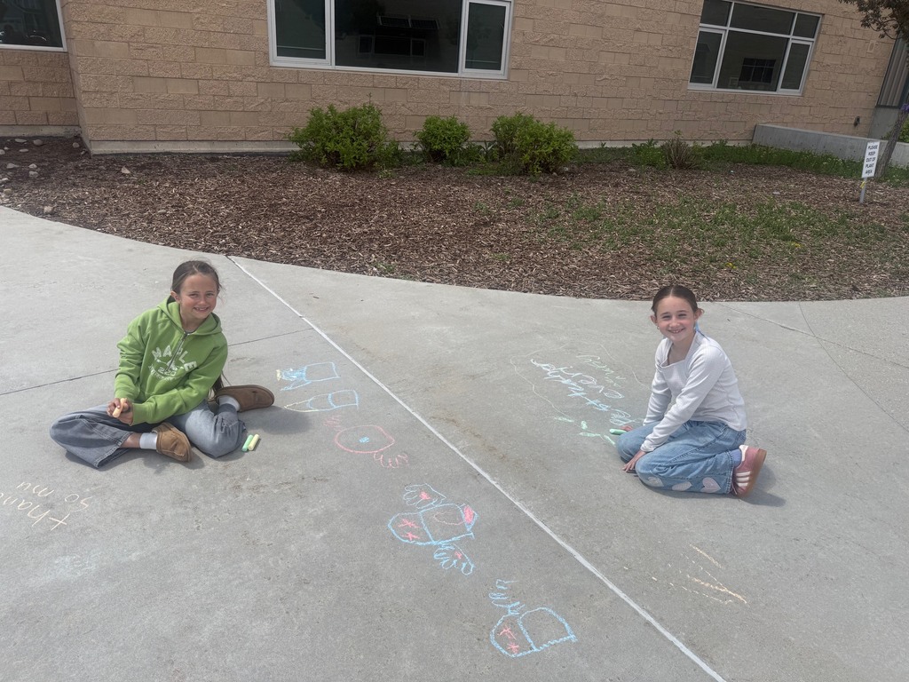 students pictured outside with their chalk art