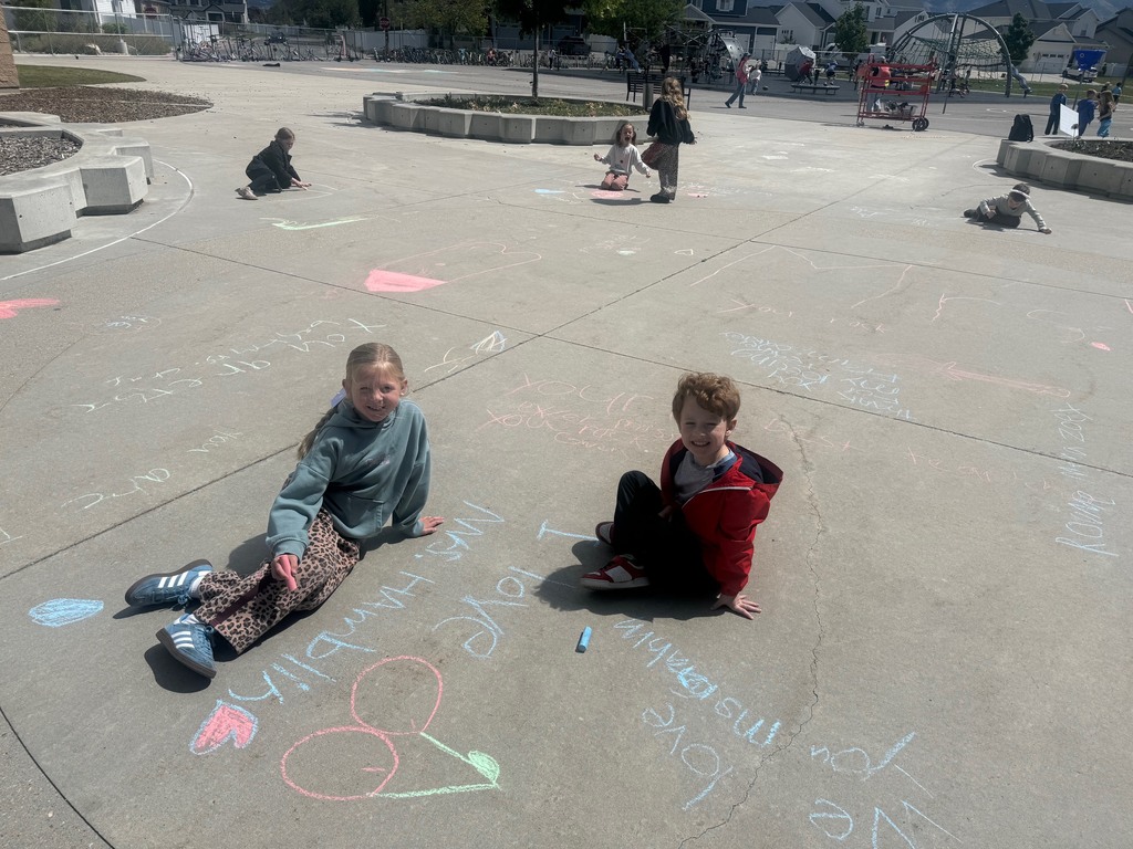 students pictured outside with their chalk art