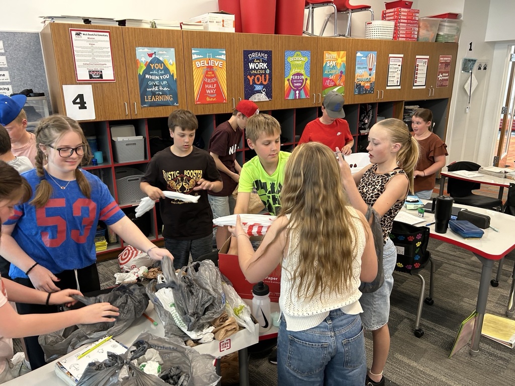 Students posing for a picture with all the grocery bags they collected. 