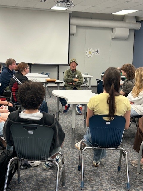 image of man in uniform speaking to students