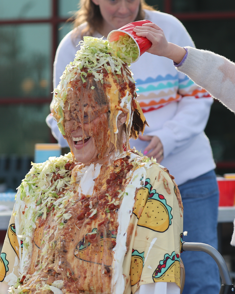 A principal having lettuce dumped on her head outside. 
