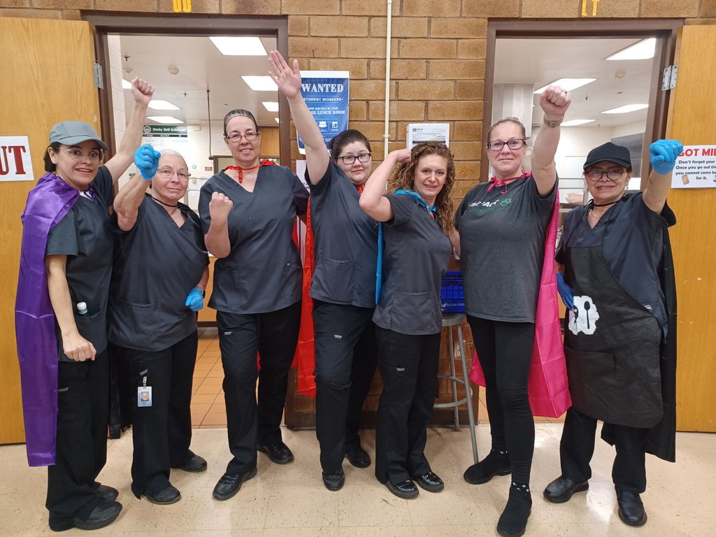 Kitchen workers on capes for hero day. 