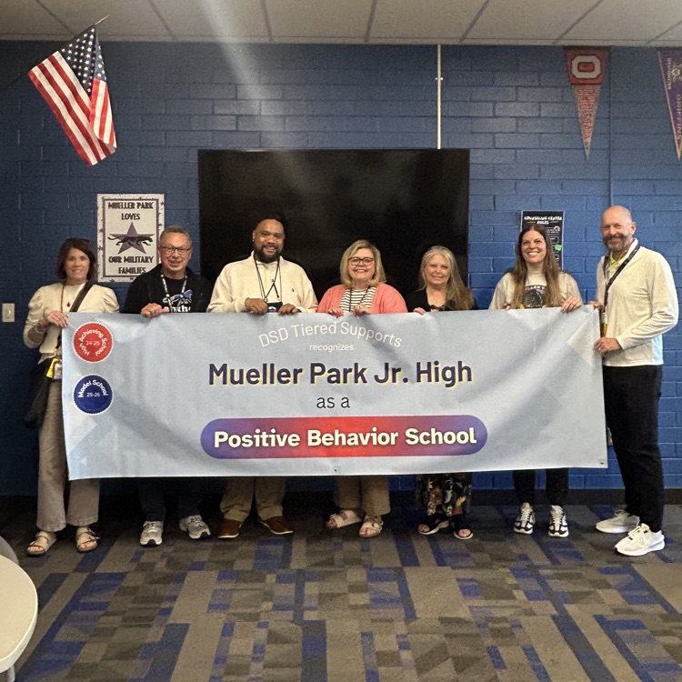 7 people stand in front of a banner that reads "DSD tiered supports recognizes Mueller Park Jr High as a Positive Behavior School"