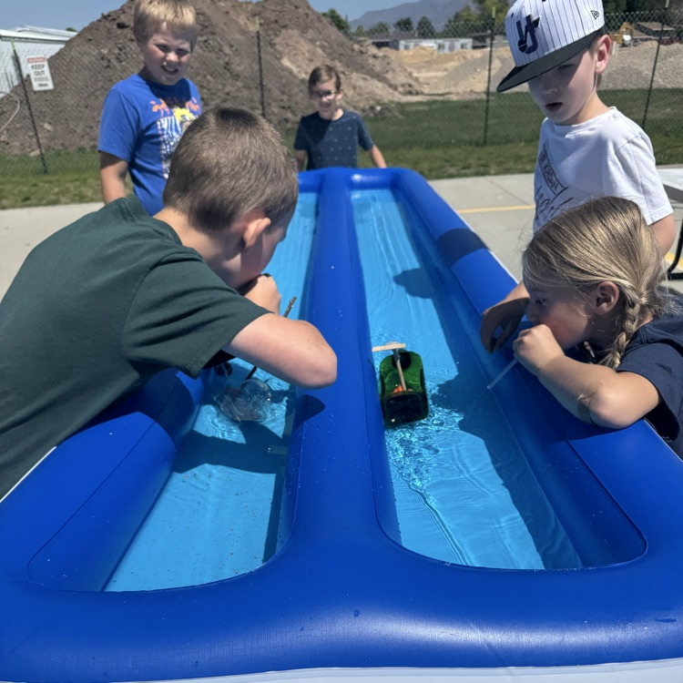 Students racing in rain gutter regatta  
