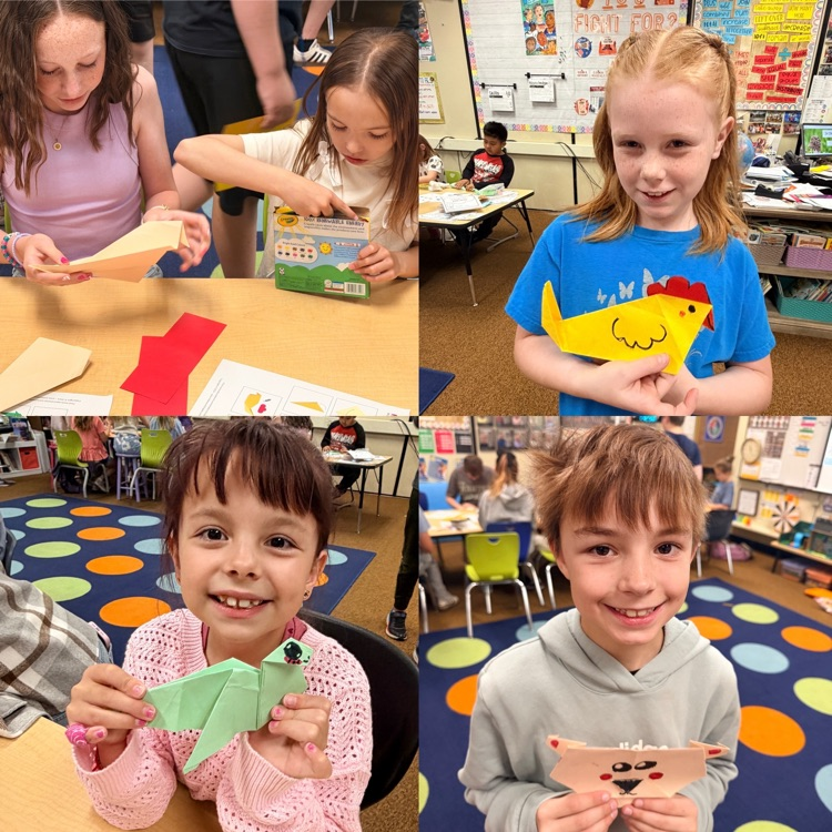 2nd graders showing off origami creations 