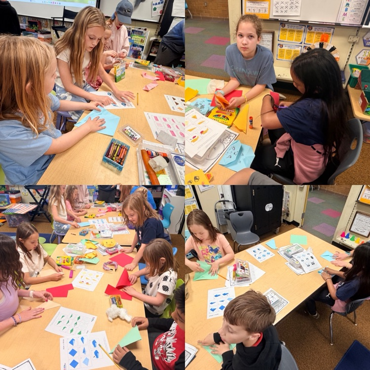 2nd graders working on origami creations with 6th graders