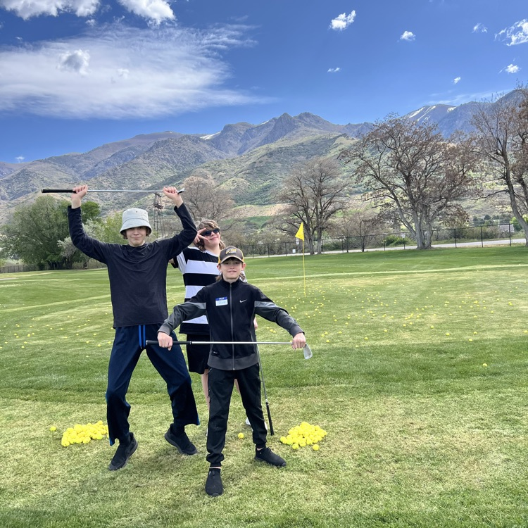 students posing with golf clubs 
