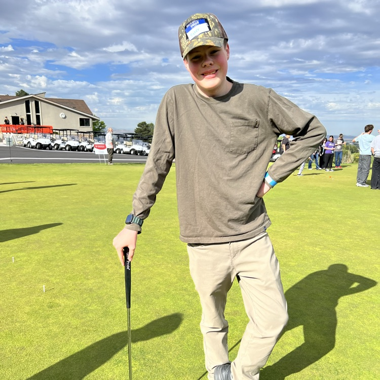 student posing with his golf club 