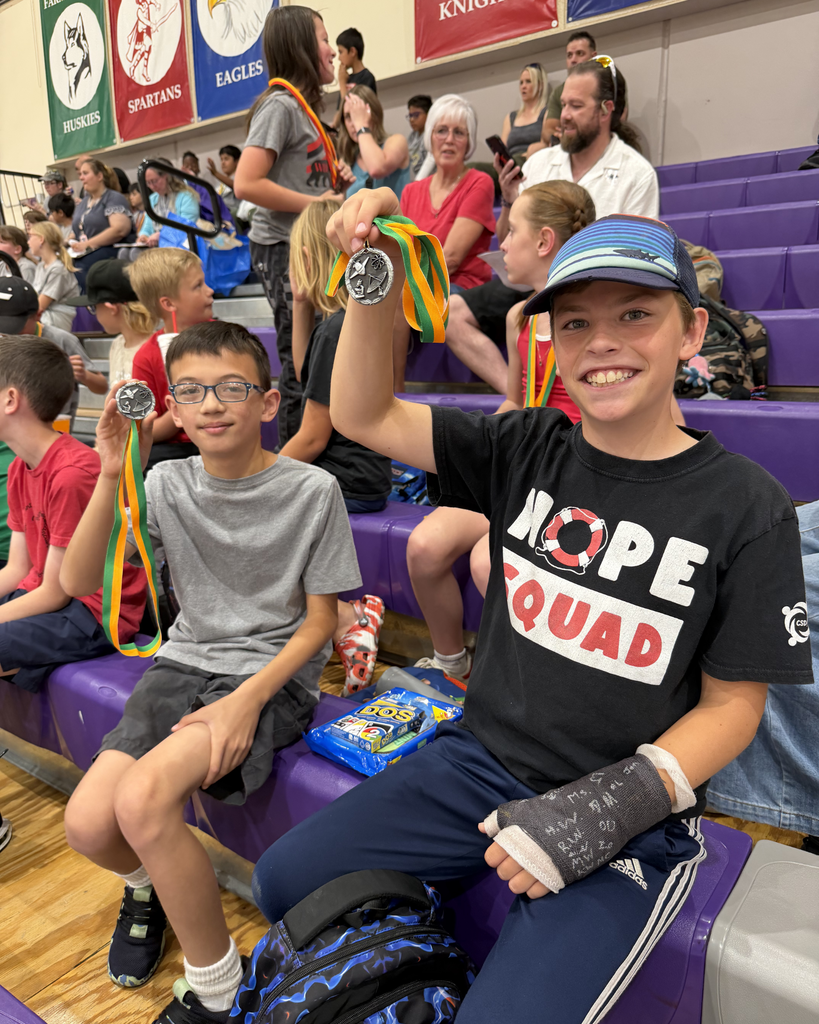 Two students posing with their medals they won at Math Olympiad.