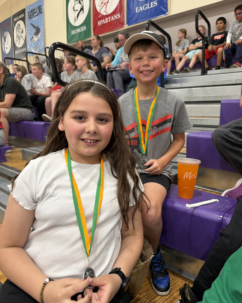 Two students posing with their medals they won at Math Olympiad.