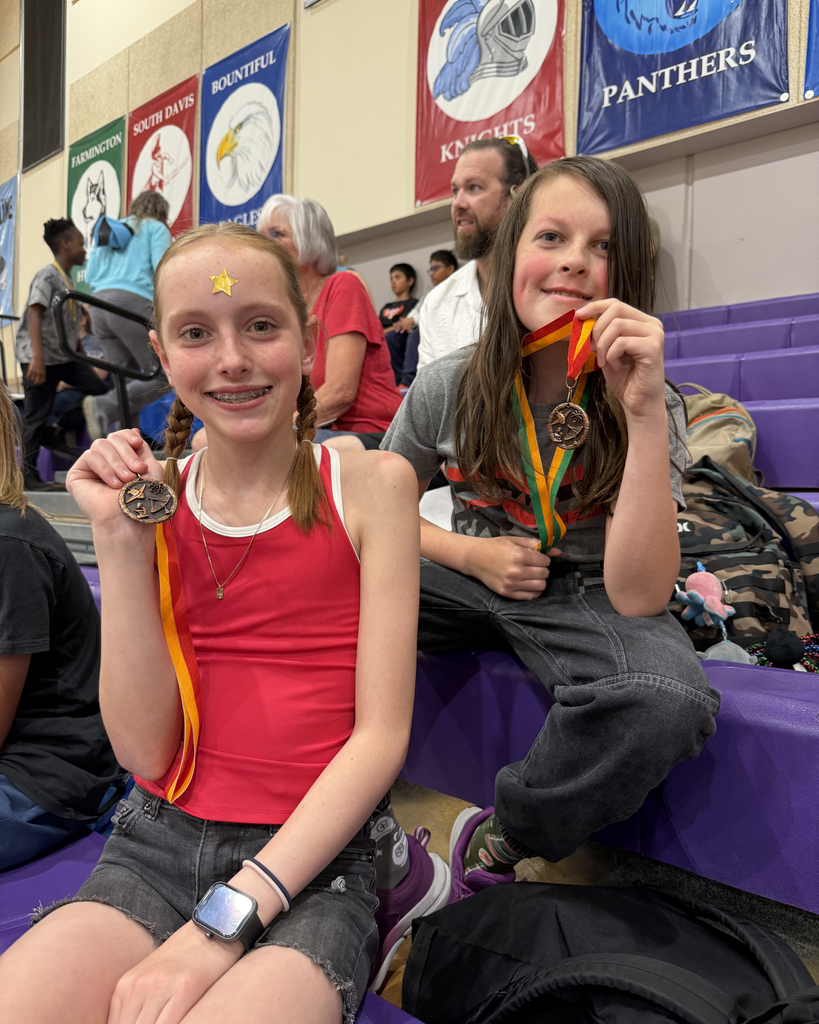 Two students posing with their medals they won at Math Olympiad.