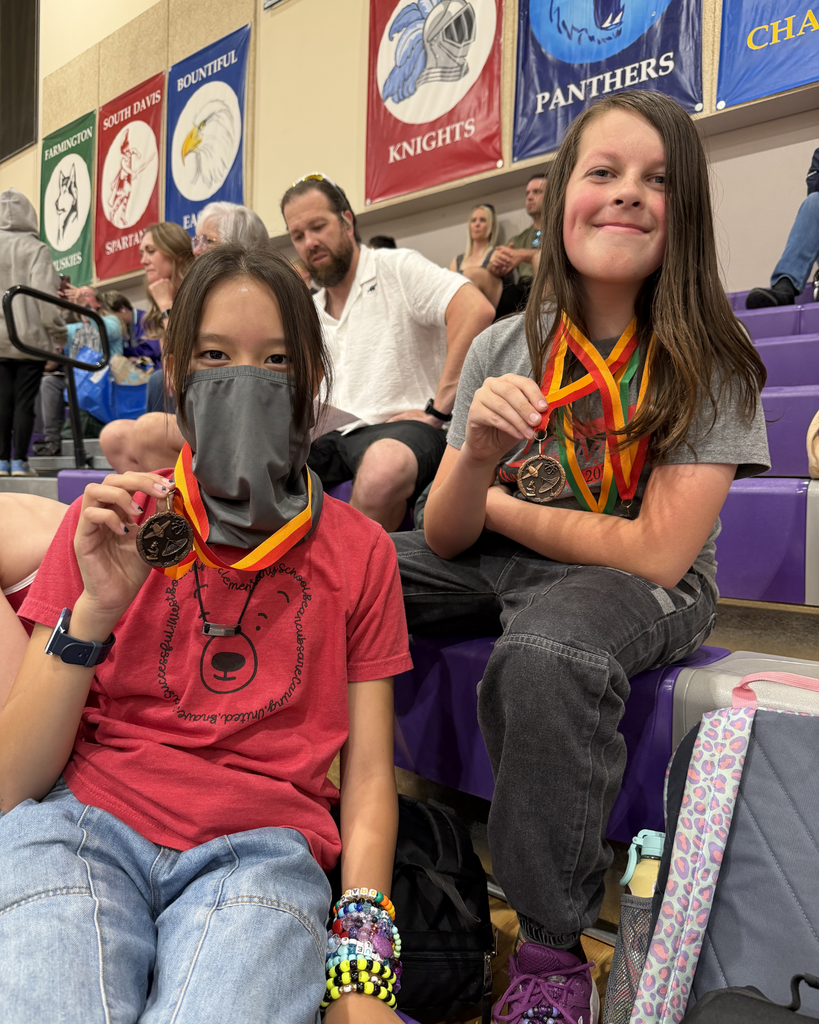 Two students posing with their medals they won at Math Olympiad.