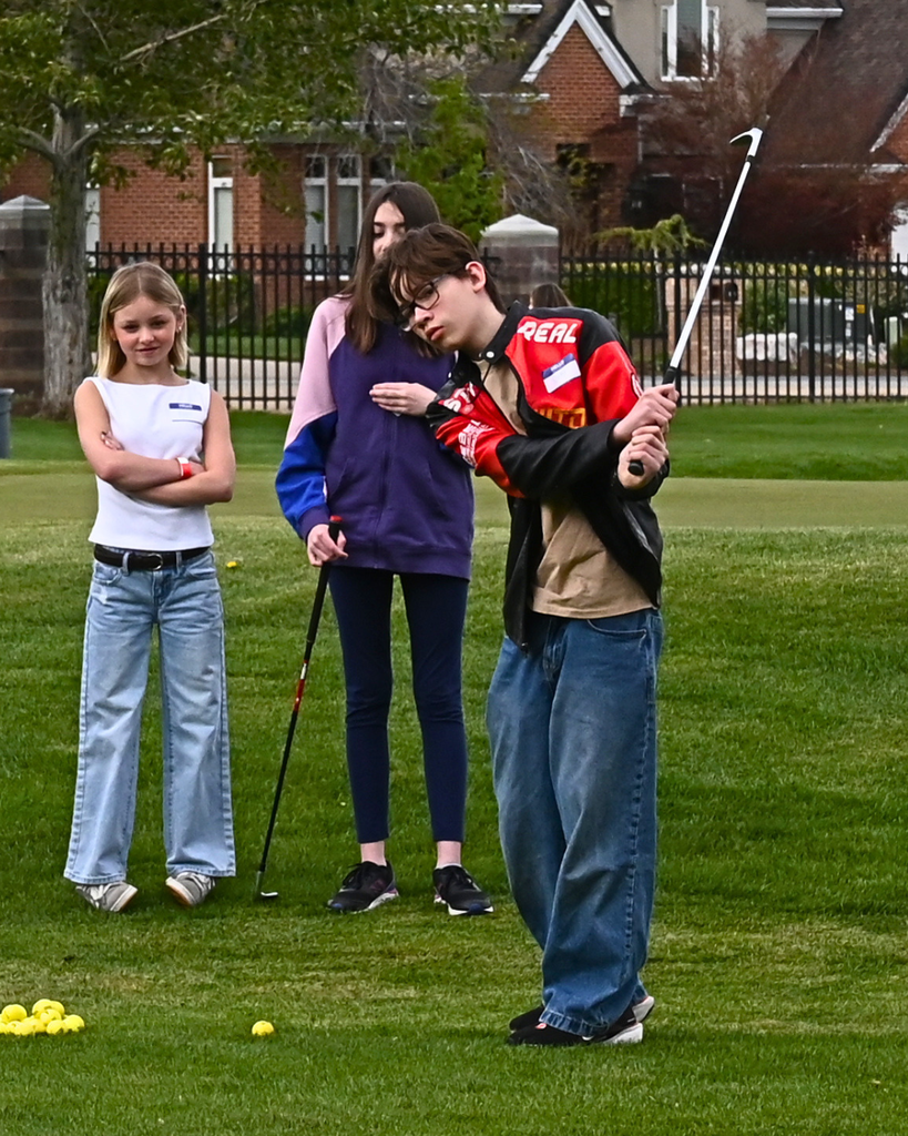 A student hits a golfball.