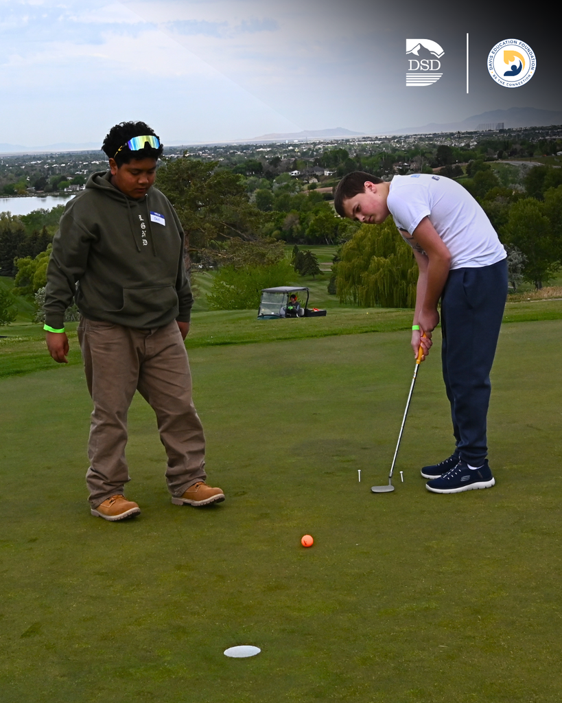 Two students golfing together.