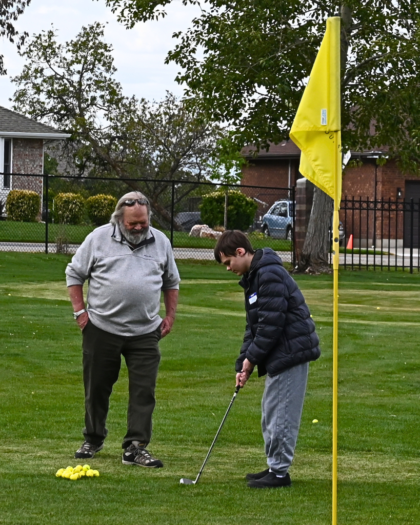 A student gets ready to put with encouragement from an adult. 