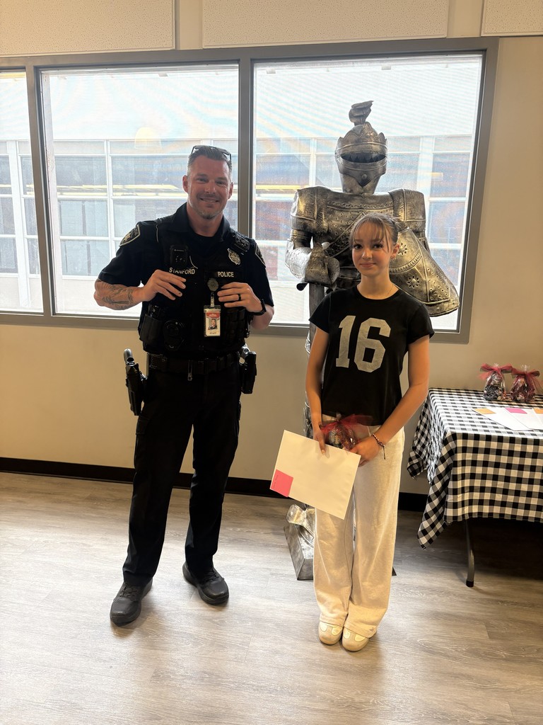image of student and school resource officer standing next to a knight statue