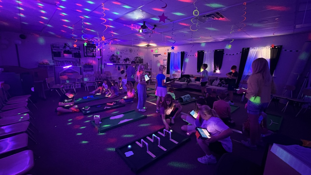 glowing lights with students holding ipads