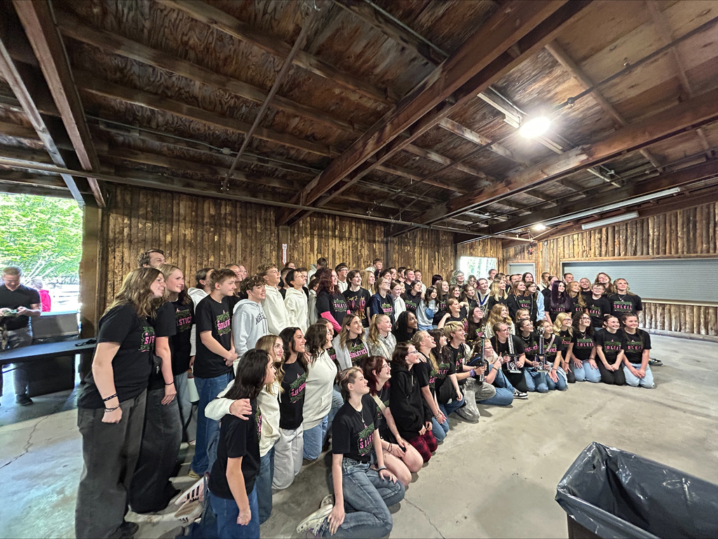 Band and choir students posing on stage.