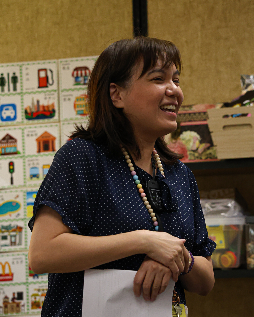 A teacher smiles excitedly as she looks to the right.