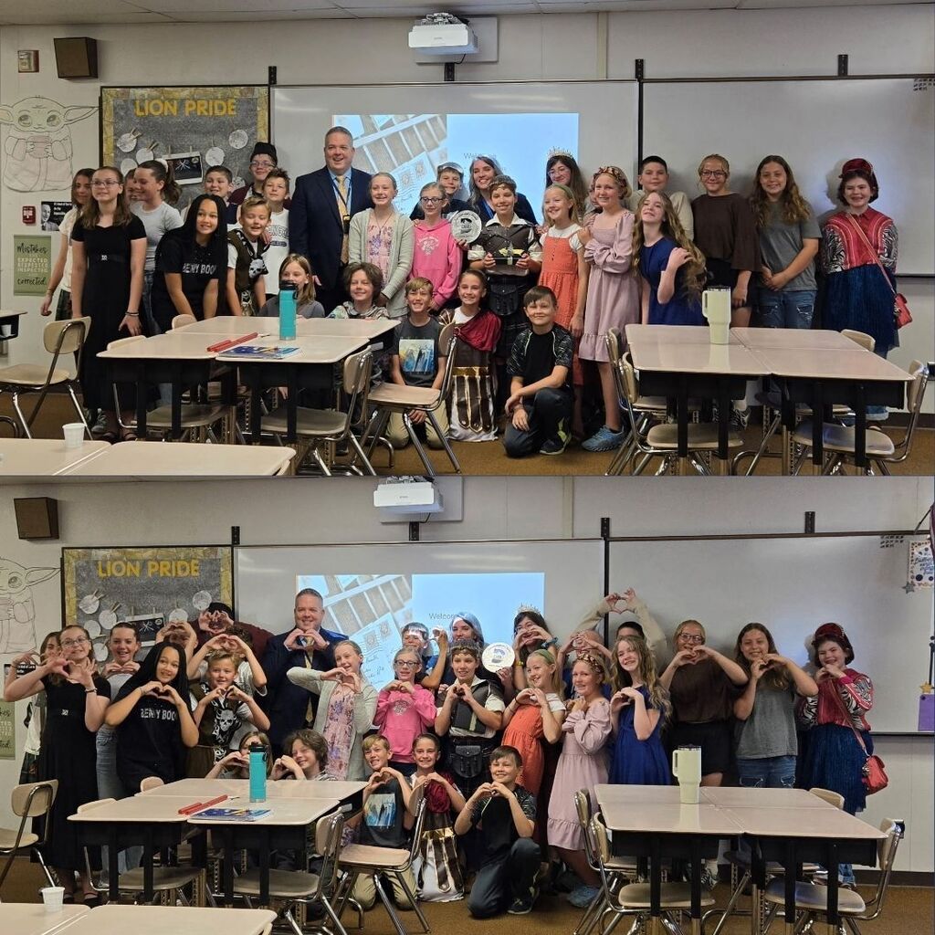 Mrs. Barlow's class posing with the Superintendent and holding her award.