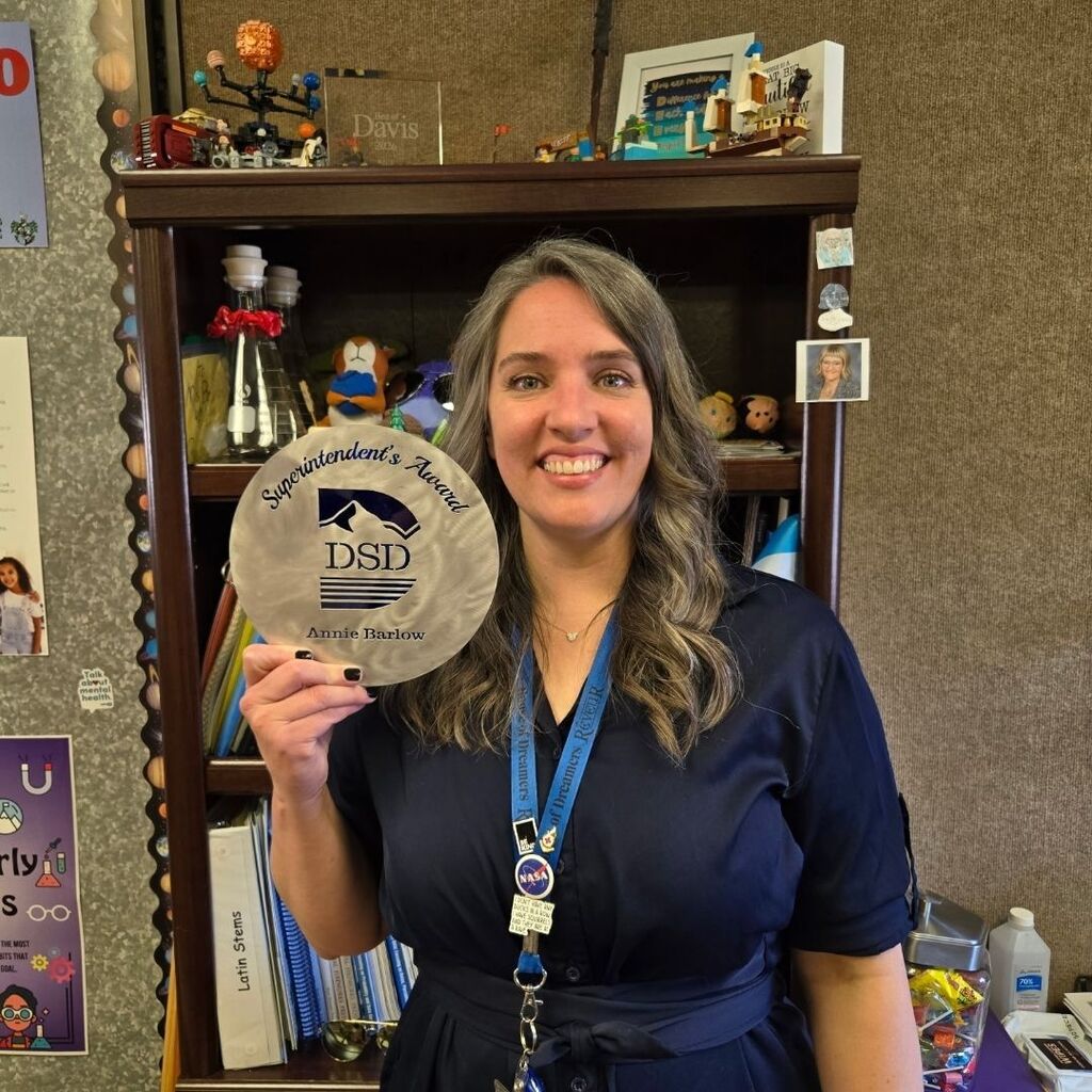 Annie Barlow standing in her classroom holding the Superintendent's Award.