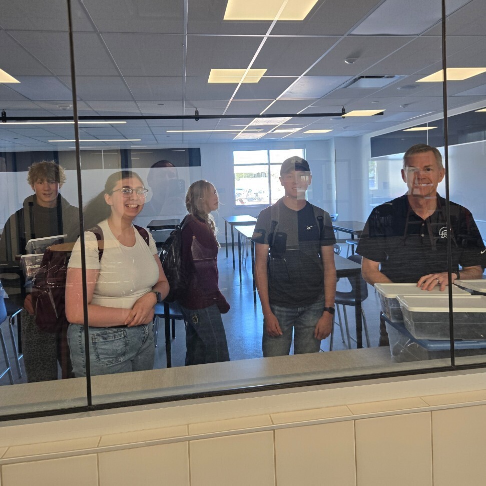students looking through the window of a new classroom
