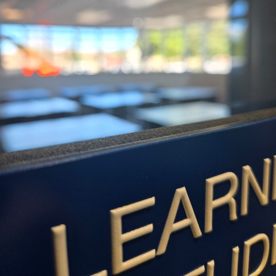 picture of classroom through windows by door with the word learn next to the window