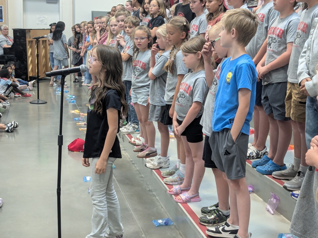 Soloist performing on stage at a school-wide assembly.