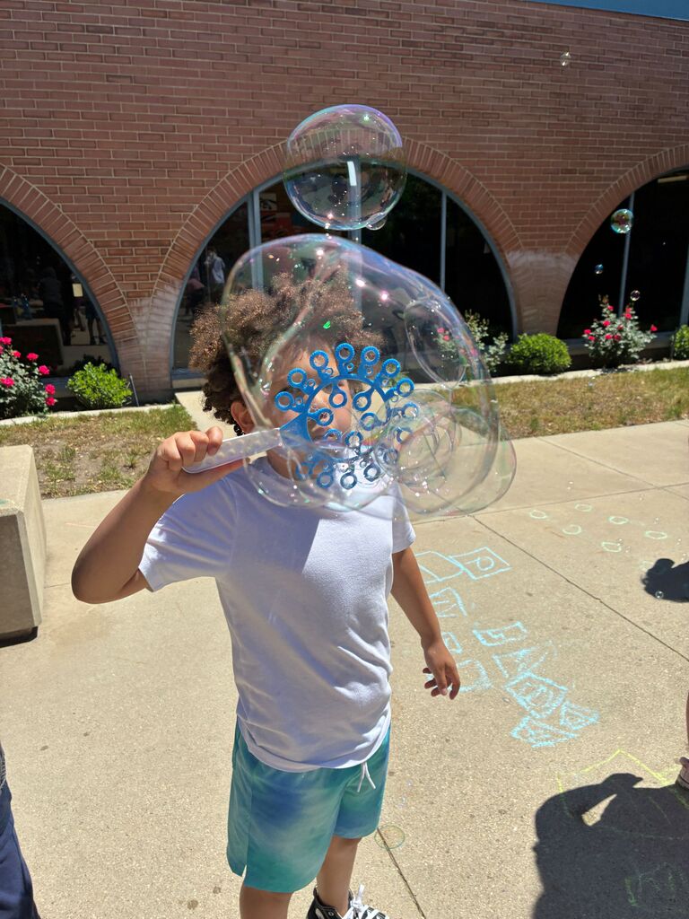 Male student outside blowing bubbles