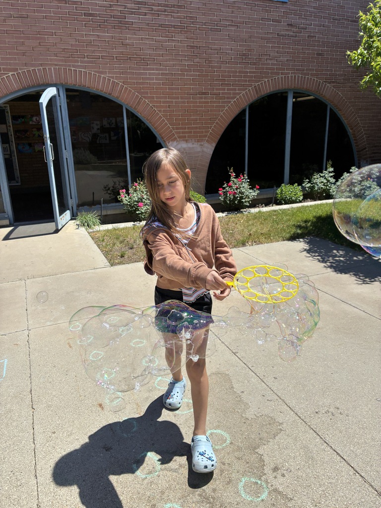 student outside spinning and making bubbles