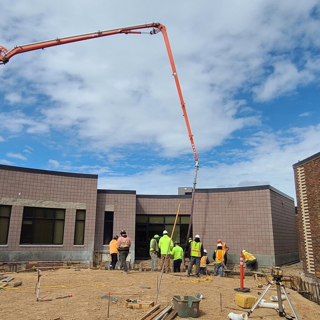 Contractors pumping concrete footings for new courtyard addition.