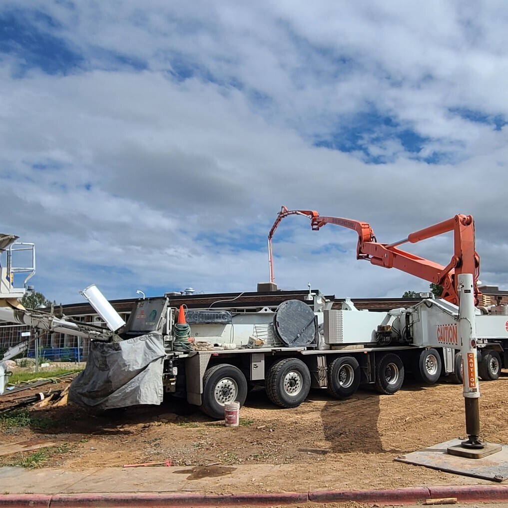 Concrete pump truck pouring footings for new courtyard addition.