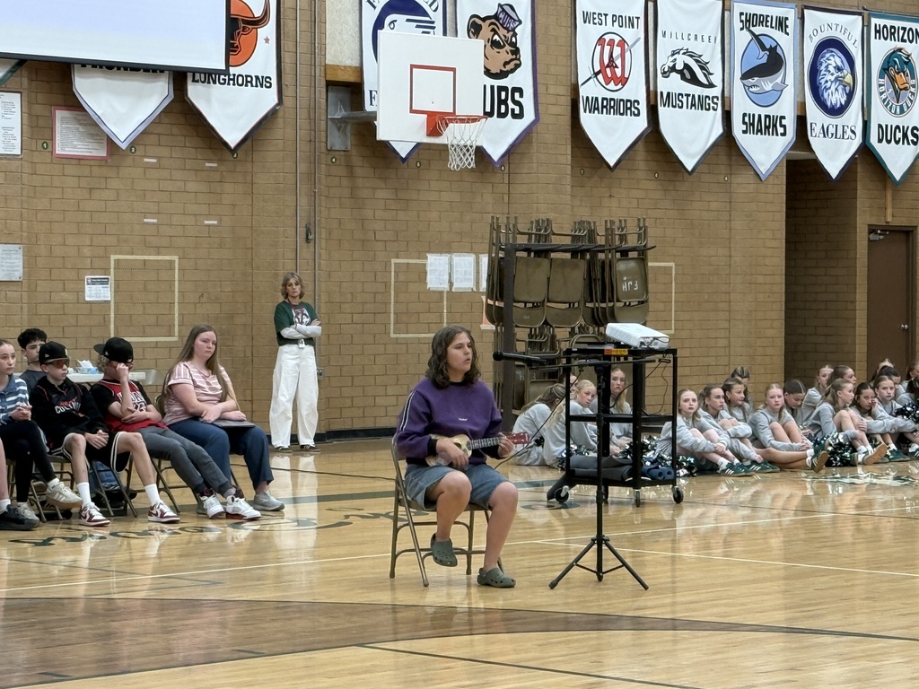 Student singing and playing the ukulele  for the talent assembly. 