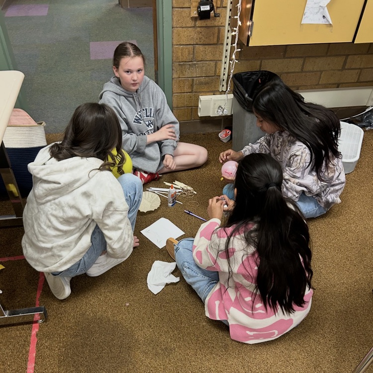 6th graders working as a team to construct bridges as part of a project.