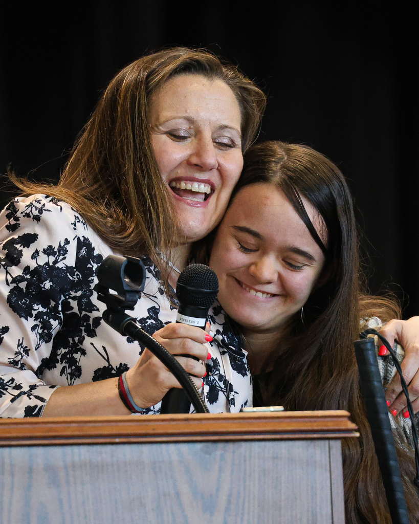 A Vista Education Campus graduate hugs her teacher.